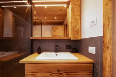 a bathroom with a sink and a mirror at Arga' New Alpine Design Apartment Central & Scenic Views in San Vito di Cadore
