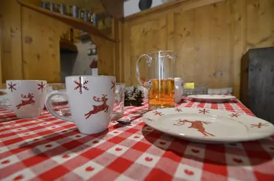 a table with two mugs and a plate on a table at Ca novella sulla Passeggiata in Cortina dʼAmpezzo