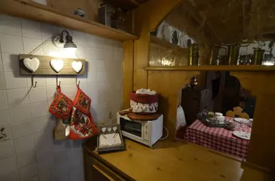 a kitchen with a microwave with a cake on a counter at Ca novella sulla Passeggiata in Cortina dʼAmpezzo