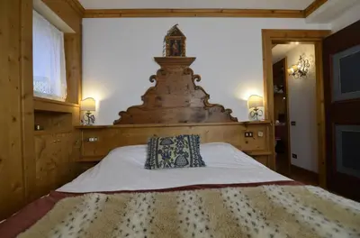 a bedroom with a large bed with a large headboard at Ca novella sulla Passeggiata in Cortina dʼAmpezzo