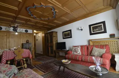 a living room with a red couch and a table at Ca novella sulla Passeggiata in Cortina dʼAmpezzo