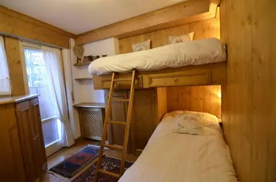 a small room with two bunk beds and a window at Ca novella sulla Passeggiata in Cortina dʼAmpezzo