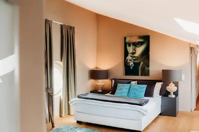a bedroom with a bed with a painting on the wall at Loft Thaler Rooms in Bolzano