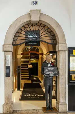 a man holding a sign in front of a building at Loft Thaler Rooms in Bolzano