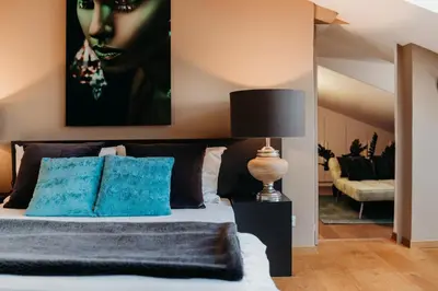 a bedroom with a bed with a painting on the wall at Loft Thaler Rooms in Bolzano