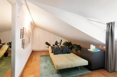 a living room with a couch in the attic at Loft Thaler Rooms in Bolzano