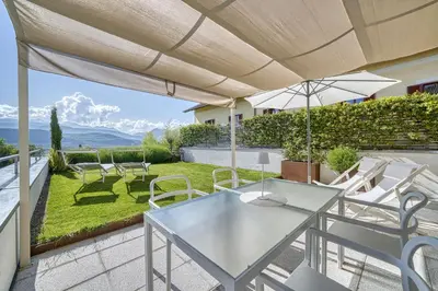 a patio with a table and chairs and an umbrella at HOMESTWENTY3 - Home three in Caldaro