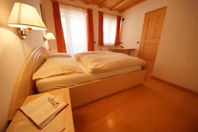 a bedroom with a bed in a room with a lamp at Residence Villa Toni in San Vigilio Di Marebbe