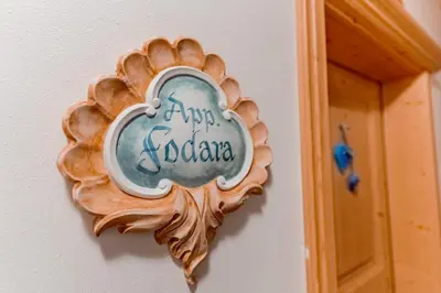 a wooden plate hanging on a wall at Residence Villa Toni in San Vigilio Di Marebbe