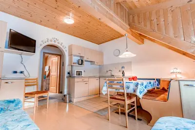 a kitchen and living room with a table and chairs at Residence Villa Toni in San Vigilio Di Marebbe