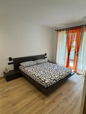 a bedroom with a bed and a large window at Renesmee Apartment in Naturno