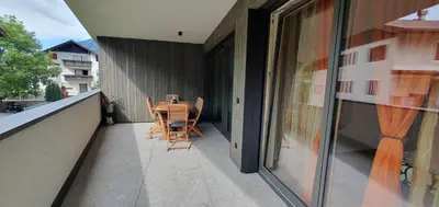 a patio with a table and chairs on a balcony at Renesmee Apartment in Naturno
