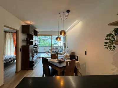 a living room with a table and a dining room at Renesmee Apartment in Naturno