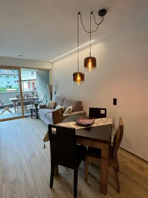 a living room with a dining room table and a couch at Renesmee Apartment in Naturno