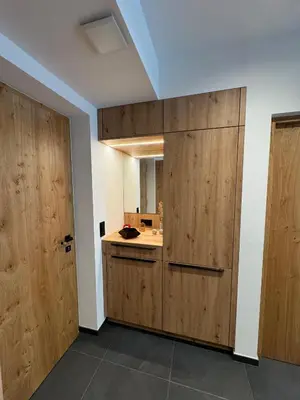 a room with a kitchen with wooden doors at Renesmee Apartment in Naturno