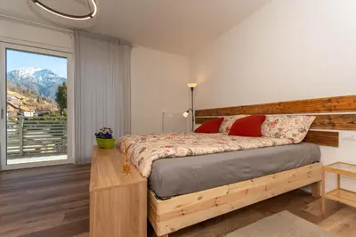 a bedroom with a bed and a large window at Casa Adriana in Agordo