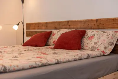 a bed with two red pillows on it at Casa Adriana in Agordo