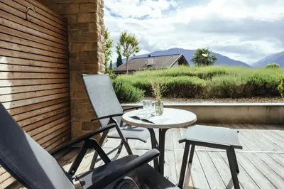 a patio with a table and two chairs on a deck at Hilburger Hotel in Schenna