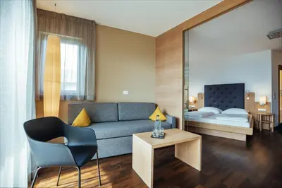 a living room with a couch and a bed at Hilburger Hotel in Schenna