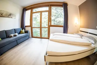 a bedroom with a bed and a couch and a window at Flow Apartments WINKEL STUDIO in Merano