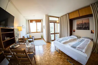 a living room with a bed and a table at Flow Apartments WINKEL ATELIER in Merano