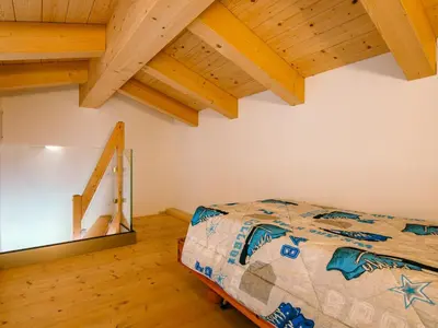 a bedroom with a bed in a room with wooden ceilings at Apartment Ciampedie by Interhome in Pera