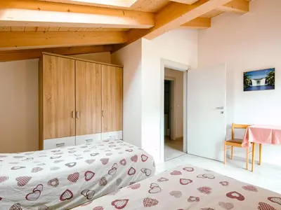a bedroom with a bed and a wooden staircase at Apartment Ciampedie by Interhome in Pera