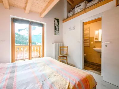 a small bedroom with a bed and a staircase at Apartment Ciampedie by Interhome in Pera