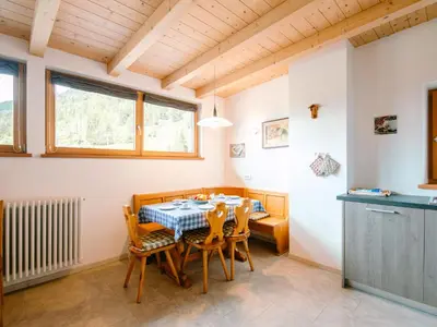 a living room with wooden ceilings and a table at Apartment Ciampedie by Interhome in Pera