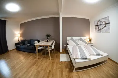 a bedroom with a bed and a table and a couch at Flow Apartments KIRCHSTEIG in Merano