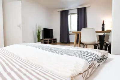 a bedroom with a bed and a table and chairs at Flow Apartments KIRCHSTEIG in Merano