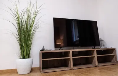 a flat screen tv sitting on top of a wooden entertainment center at Flow Apartments KIRCHSTEIG in Merano