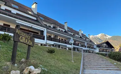 a large building with a sign in front of it at Il Focolare del Cermis in Cavalese