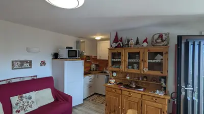 a kitchen with a red couch in a room at Il Focolare del Cermis in Cavalese