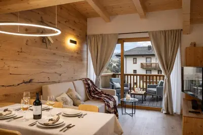 a living room with a couch and a table at ALPINE LOFT - Residence Veronza con piscina, Dolomiti Affitti in Cavalese