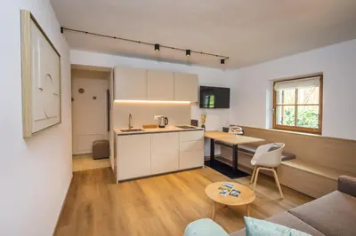 a kitchen and living room with a couch and a table at Tagenhof Mountain Living in Meluno