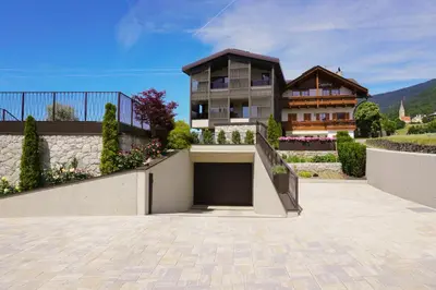 a house with a garage in front of it at Tagenhof Mountain Living in Meluno