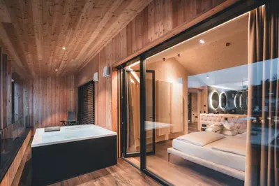 a room with a bed and a table in a room at Luxury Spa Suite in Siusi