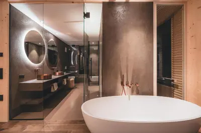 a bathroom with a tub and two sinks and a mirror at Luxury Spa Suite in Siusi