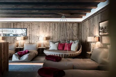 a living room with a hanging couch and chairs at Luxury Spa Suite in Siusi