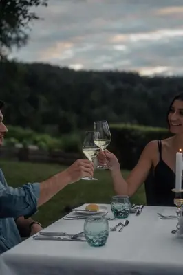 a man and woman holding glasses of wine at a table at Luxury Spa Suite in Siusi