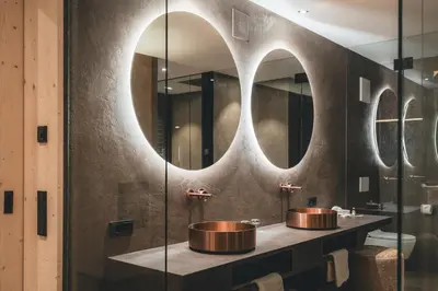 a bathroom with two sinks and two mirrors at Luxury Spa Suite in Siusi