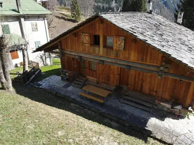 a wooden building with a bench in front of it at Tabià Su'n Coi in Alleghe