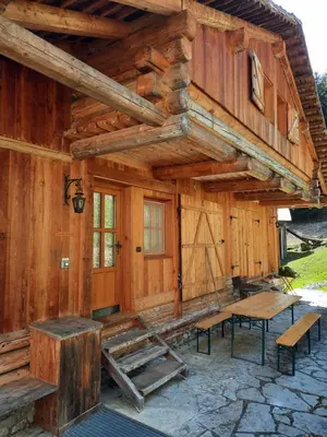 a log cabin with a picnic table and benches outside at Tabià Su'n Coi in Alleghe