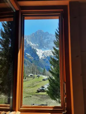 a window with a view of a snow covered mountain at Tabià Su'n Coi in Alleghe