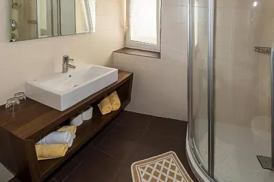 a bathroom with a sink and a shower at Garni Hotel Dorothea in Tirolo