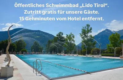 a swimming pool with mountains in the background at Garni Hotel Dorothea in Tirolo