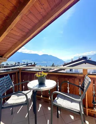 a patio with two chairs and a table on a balcony at Garni Hotel Dorothea in Tirolo
