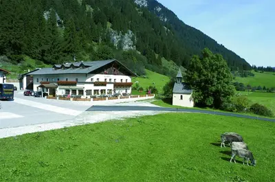 a log cabin in the snow with a mountain at Hotel Larchhof Ratschings in Racines