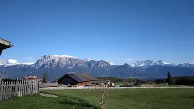 a house in a field with mountains in the background at Oberpfaffstaller in Longomoso